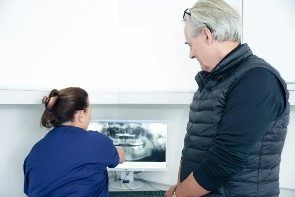 Klinikpersonale viser røntgenbillede til patient hos tandlæge på Amager