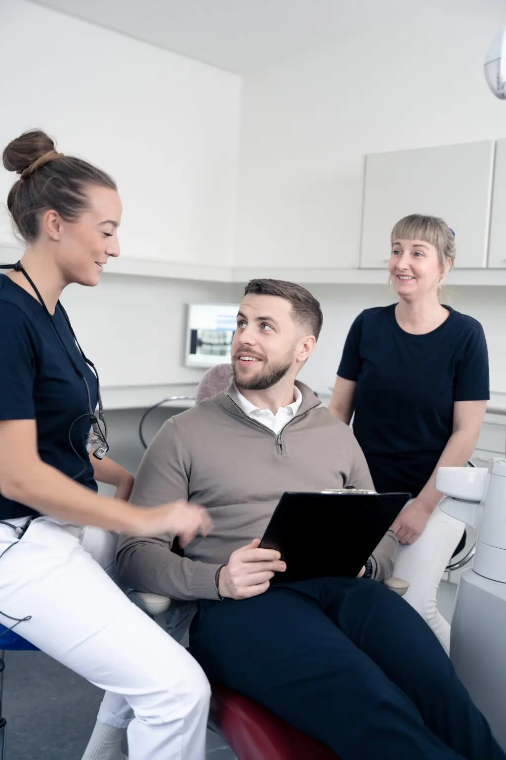 Mandlig patient i samtale med tandlæge og klinikpersonale på tandklinik i Amager